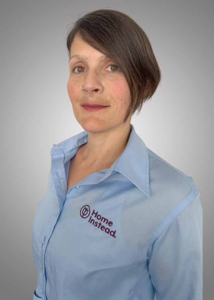 Frau mit kurzen braunen Haaren und blauer Bluse