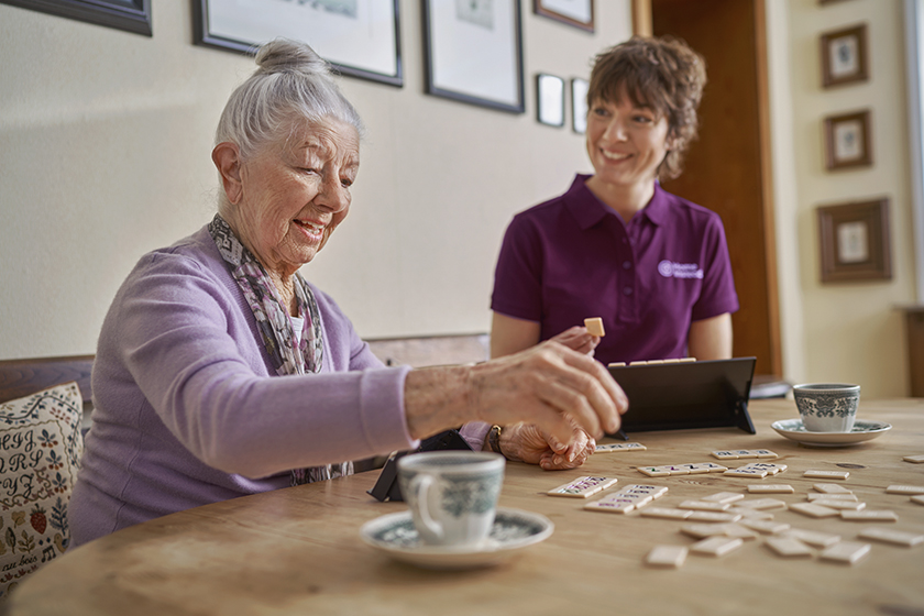 Seniorin spielt mit Betreuungskraft