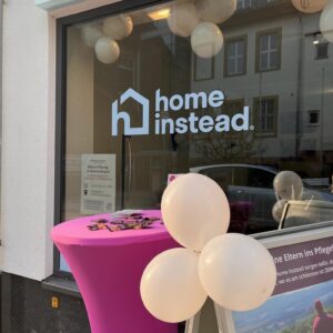 Stehtisch, Aussteller und Ballons vorm Fenster