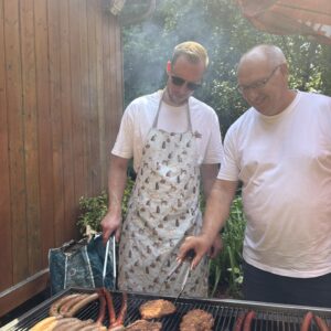 Zwei Männer grillen Fleisch und Grillkäse