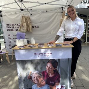 Elena steht neben dem Infostand